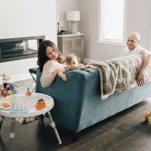 Mother and father reclining on sofa with baby daughter