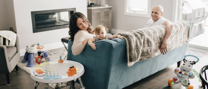 Mother and father reclining on sofa with baby daughter